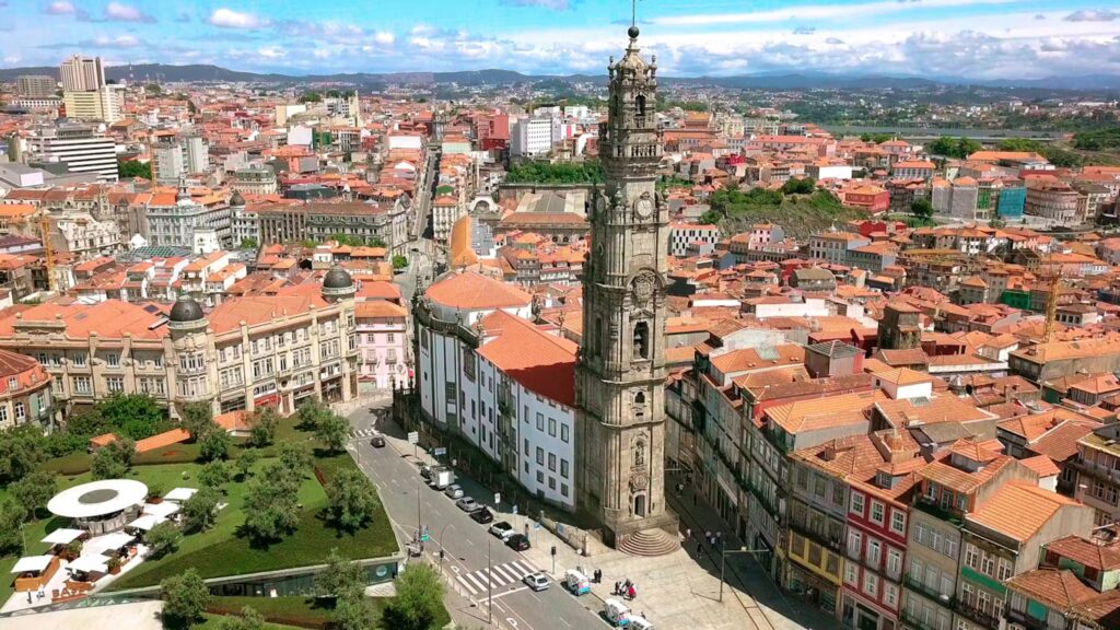 Aerial view of Catedral Do Porto, Portugal, showcasing its bell tower and the city's red-tiled rooftops.